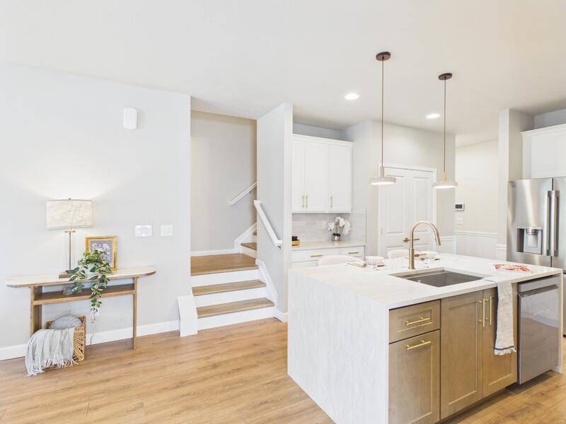 Kitchen island with sink and the staircase to the upper level in the background