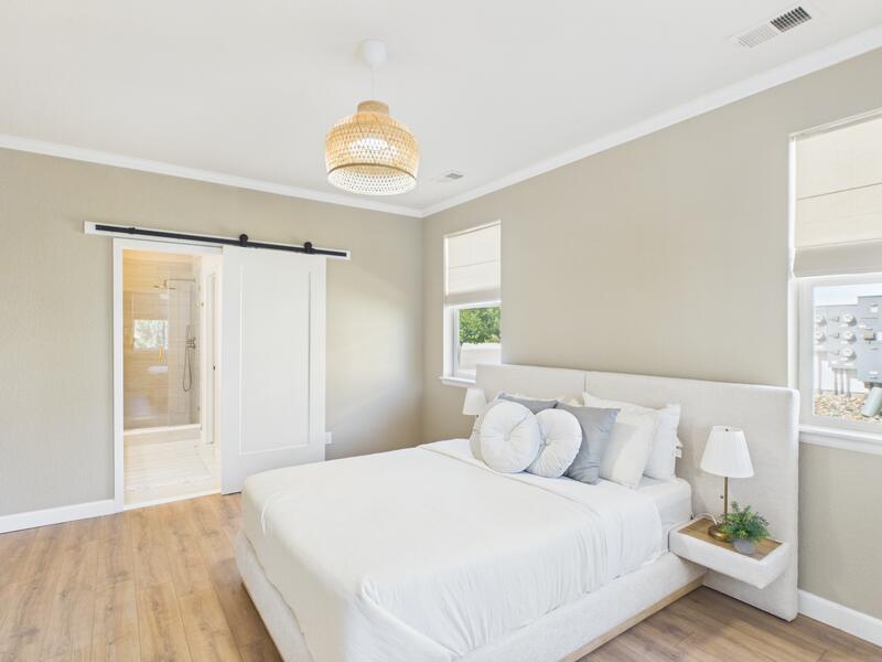 Main-level suite bedroom with a barn door leading to the en suite bathroom