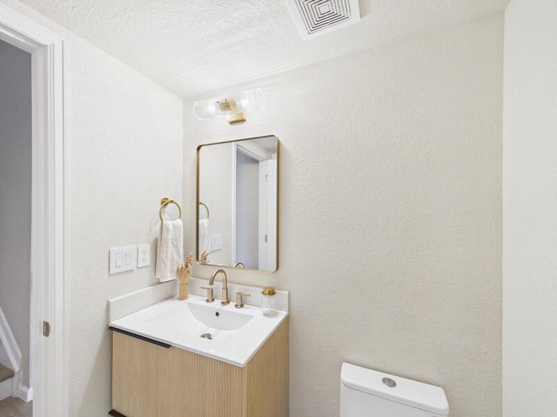 Main-level powder bathroom with an oak vanity and brass fixtures