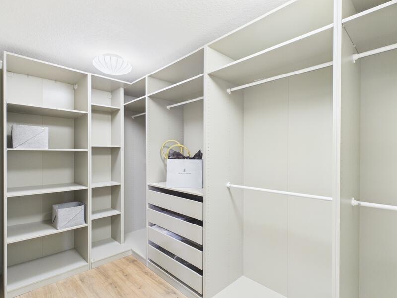 Primary walk-in closet with built-in shelving and drawers